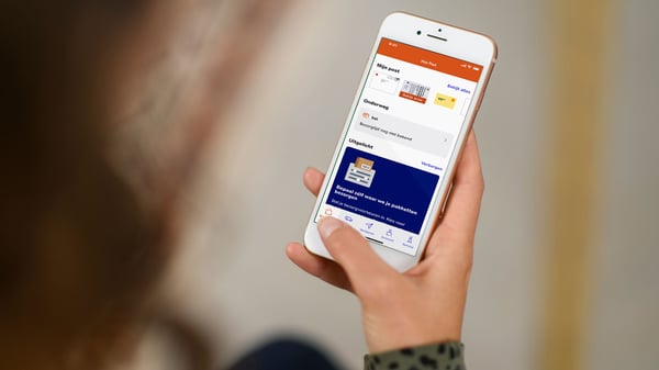 Klant bekijkt de PostNL-app met track-en-trace-informatie op een smartphone.