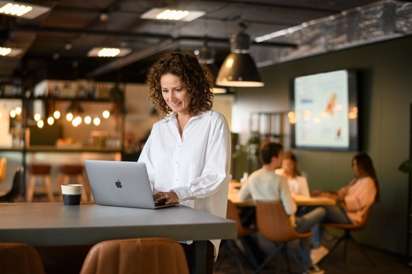 Zakenvrouw werkt op haar laptop in een bedrijfskantine