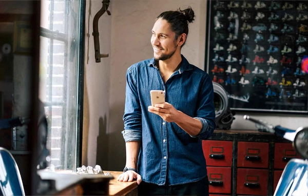 Lachende man met telefoon in zijn hand